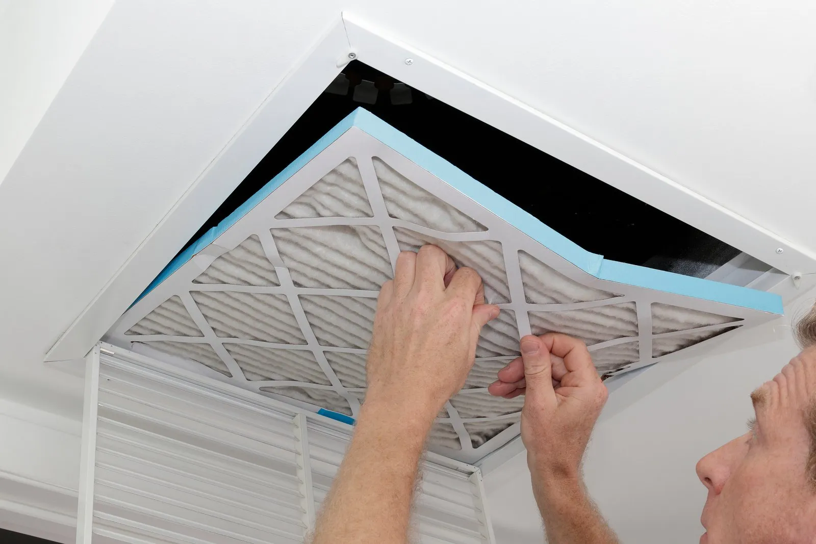 Technician cleaning an air duct vent in a Northglenn home